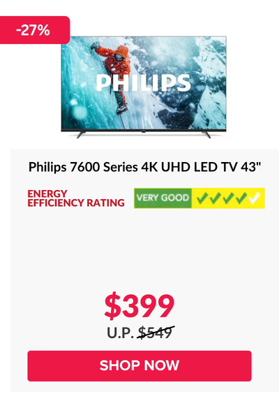 Man in a gray blazer over a dark gray shirt standing on stairs in an urban background.