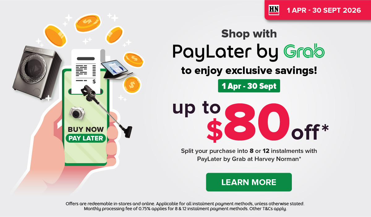 Woman wearing an olive green blazer and light blue jeans walking in an urban setting.