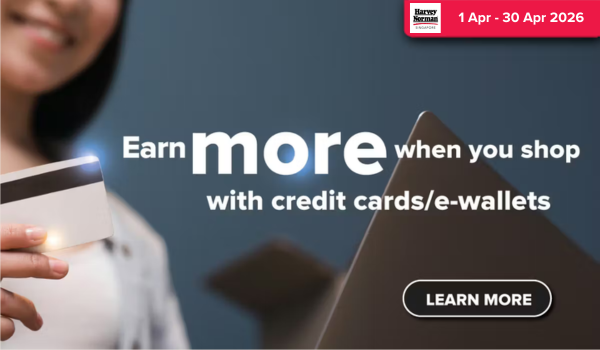 Woman wearing an olive green blazer and light blue jeans walking in an urban setting.