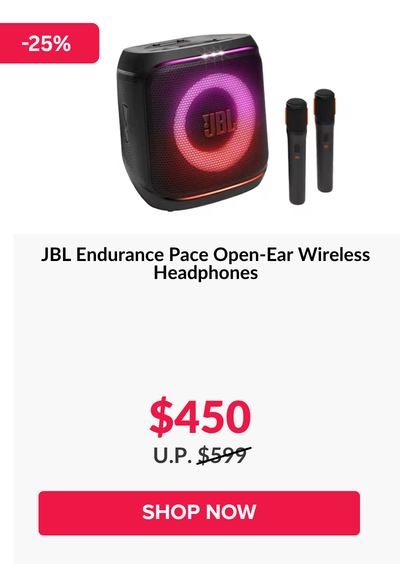 Woman wearing an olive green blazer and light blue jeans walking in an urban setting.