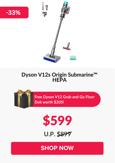 Man in a gray blazer over a dark gray shirt standing on stairs in an urban background.