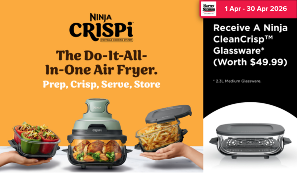 Man in a gray blazer over a dark gray shirt standing on stairs in an urban background.