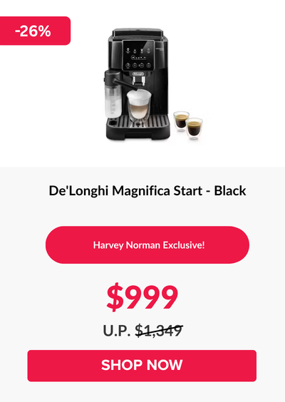 Man in a gray blazer over a dark gray shirt standing on stairs in an urban background.