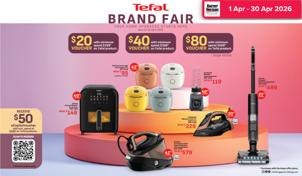 Man in a gray blazer over a dark gray shirt standing on stairs in an urban background.