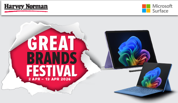 Man in a gray blazer over a dark gray shirt standing on stairs in an urban background.