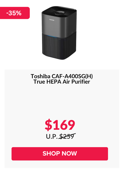 Woman wearing an olive green blazer and light blue jeans walking in an urban setting.