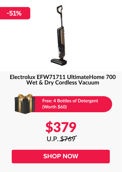 Man in a gray blazer over a dark gray shirt standing on stairs in an urban background.