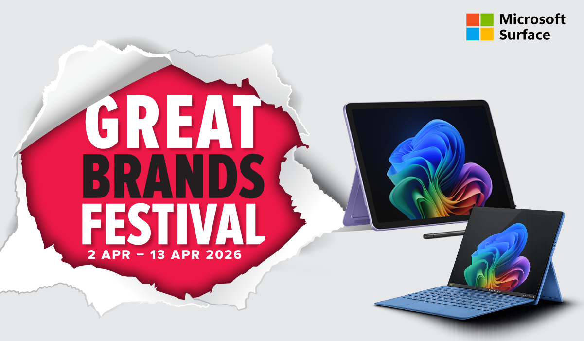 Man in a gray blazer over a dark gray shirt standing on stairs in an urban background.