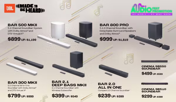 Man in a gray blazer over a dark gray shirt standing on stairs in an urban background.