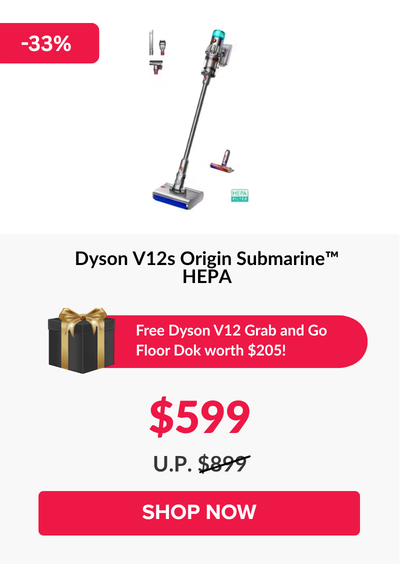 Man in a gray blazer over a dark gray shirt standing on stairs in an urban background.