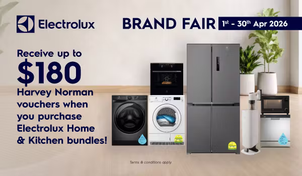 Woman wearing an olive green blazer and light blue jeans walking in an urban setting.