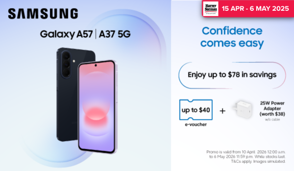 Man in a gray blazer over a dark gray shirt standing on stairs in an urban background.