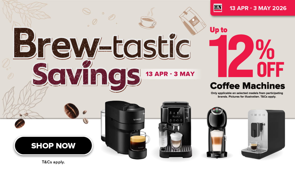 Woman wearing an olive green blazer and light blue jeans walking in an urban setting.