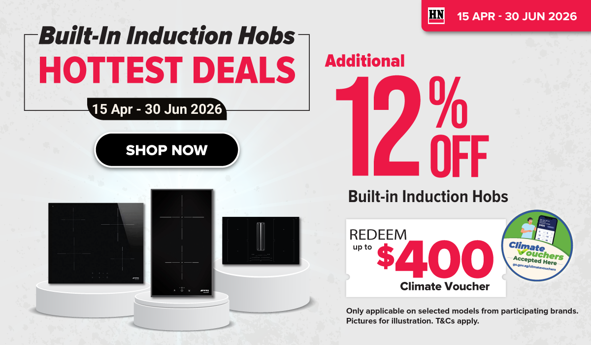 Man in a gray blazer over a dark gray shirt standing on stairs in an urban background.