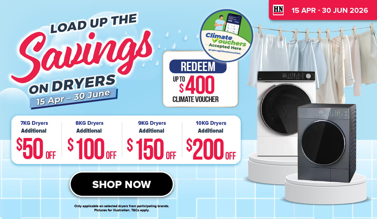 Woman wearing an olive green blazer and light blue jeans walking in an urban setting.