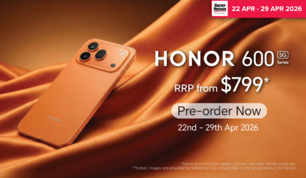 Man in a gray blazer over a dark gray shirt standing on stairs in an urban background.