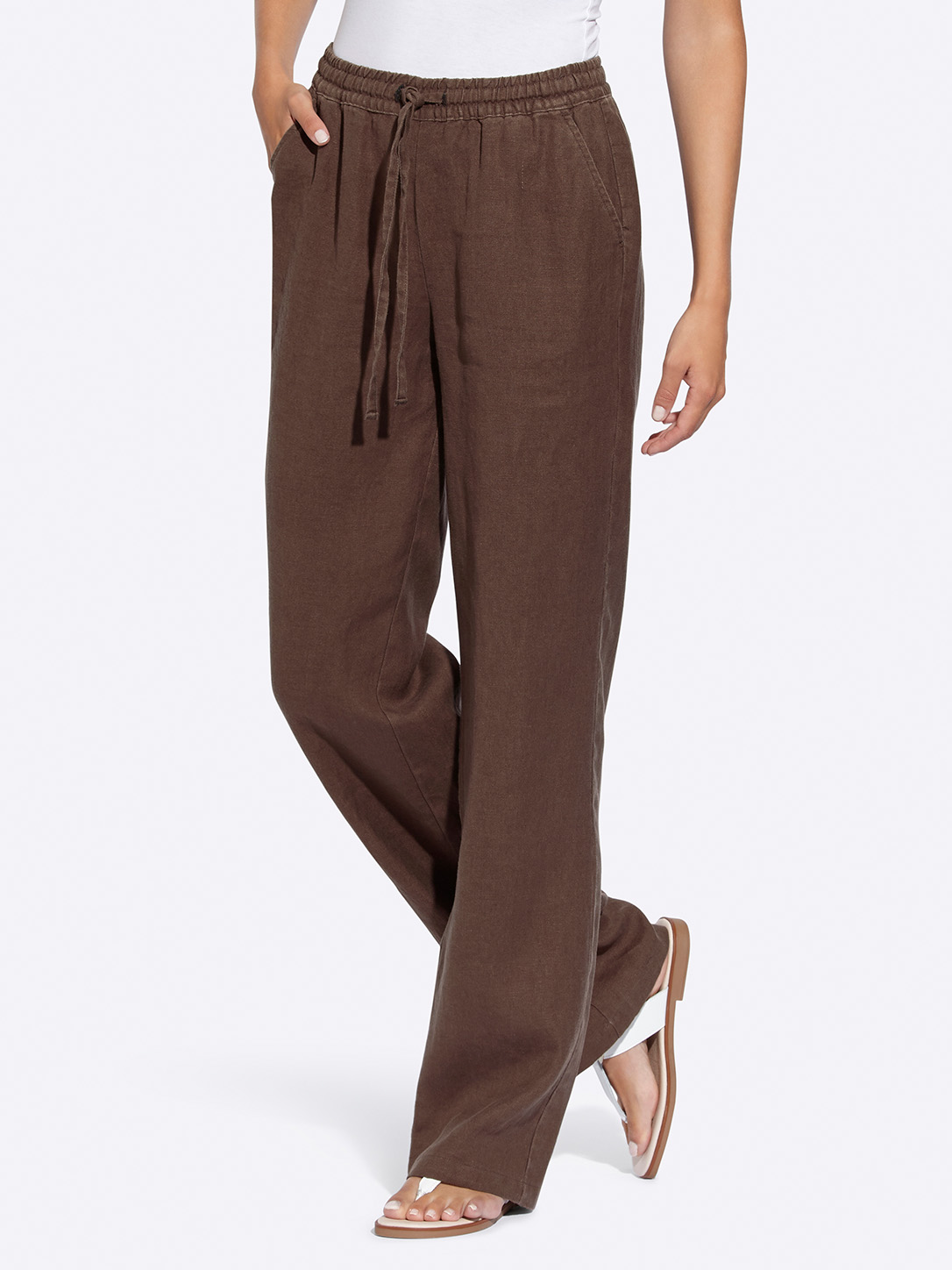 Braune, weite Damenhose mit Tunnelzugbund, kombiniert mit weißen Sandalen und weißem Oberteil
