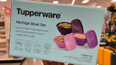 Hand holding a box of a purple tupperware six-piece set