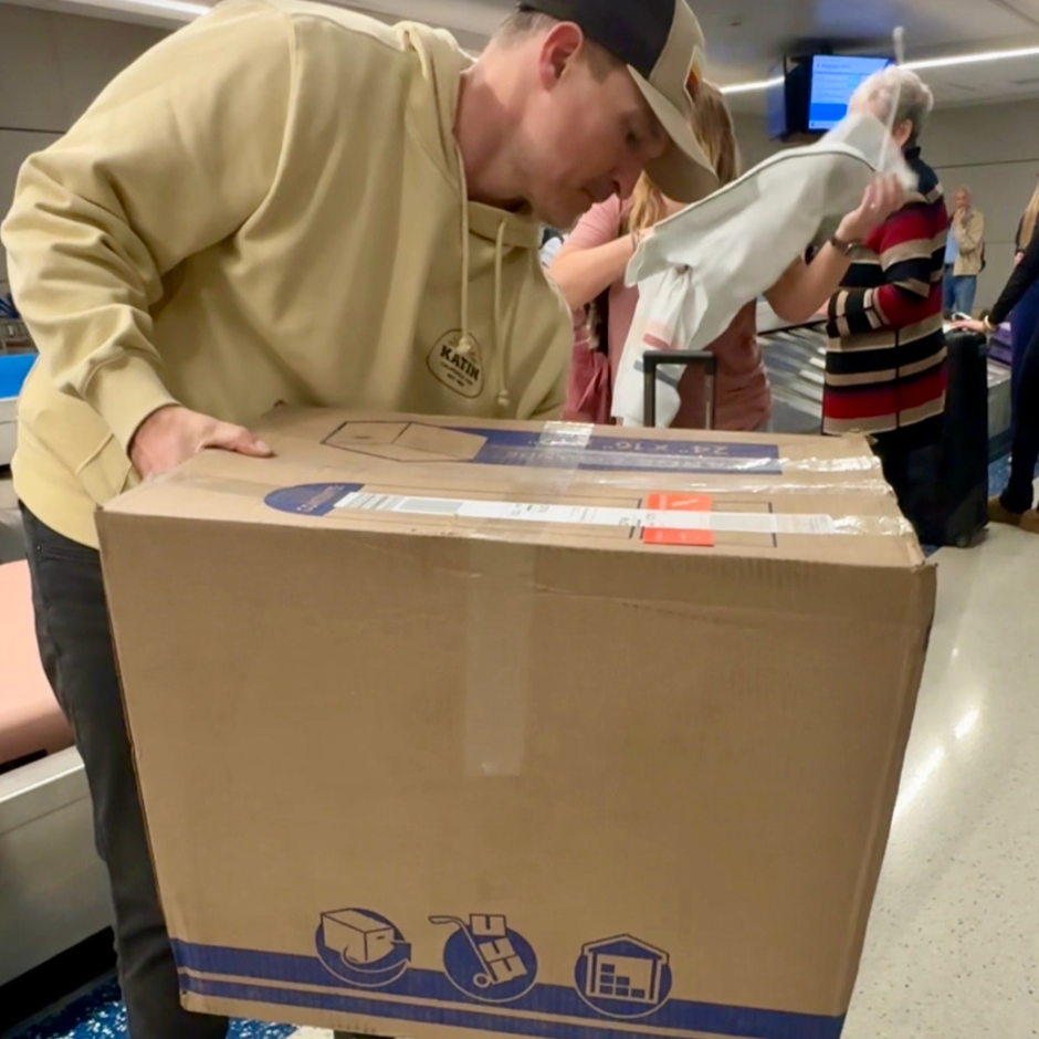 Man carrying giant box through airport