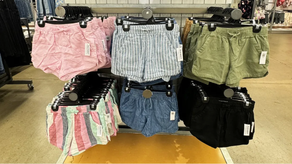 rack of patterned and solid-colored shorts on a store rack