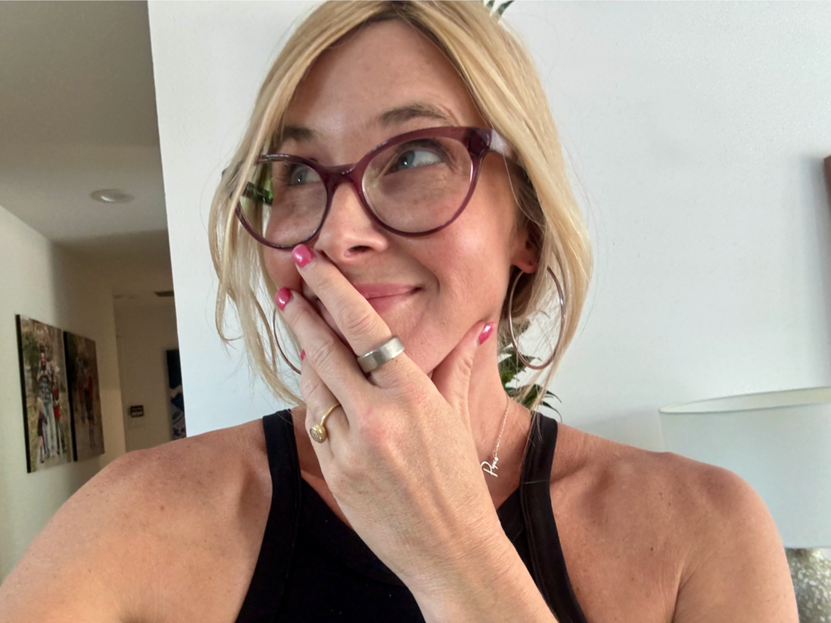 a woman wearing glasses and a ring on her finger