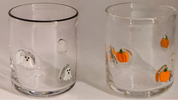 two halloween glasses with ghosts and pumpkins on them on a table