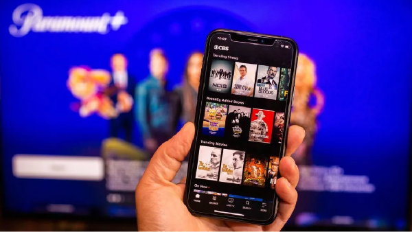 person holding a phone in front of a tv