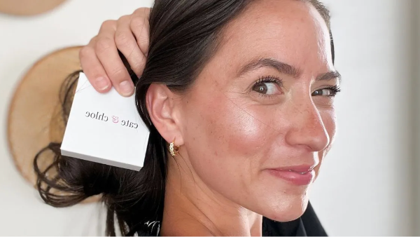woman wearing crustal hoop earrings and holding a gift box