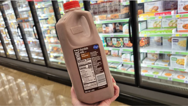 hand holding up a Half-Gallon of Kroger Chocolate Milk in a grocery store