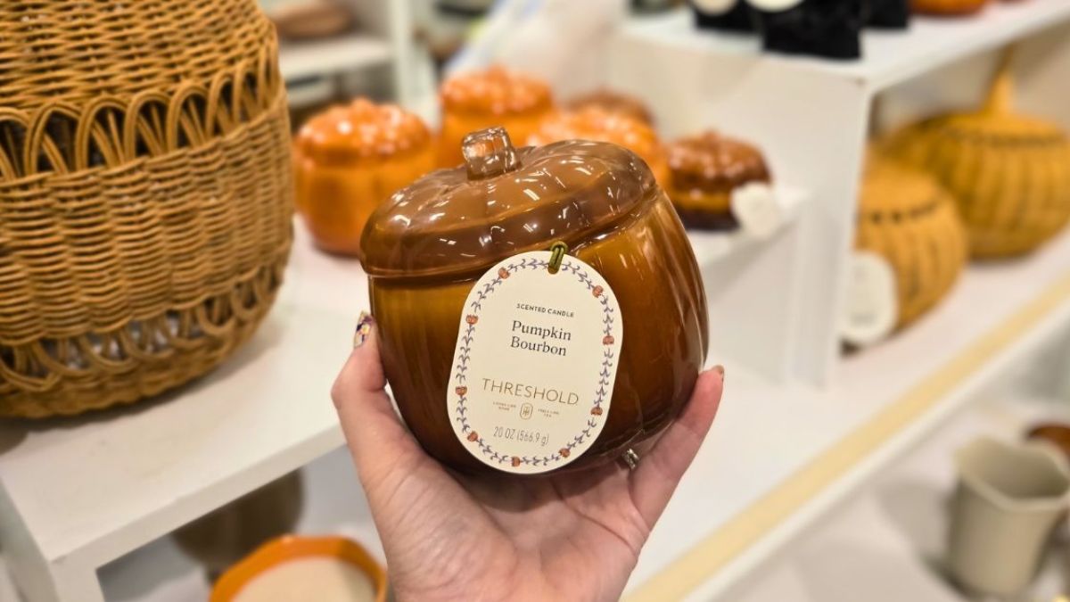 hand holding pumpkin candle