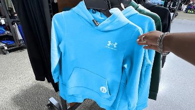 person touching blue under armour hoodie