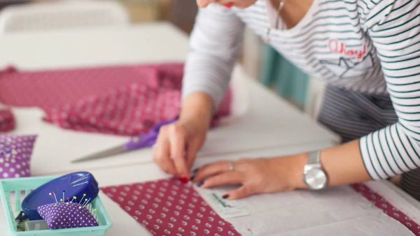 woman cutting fabric on a table