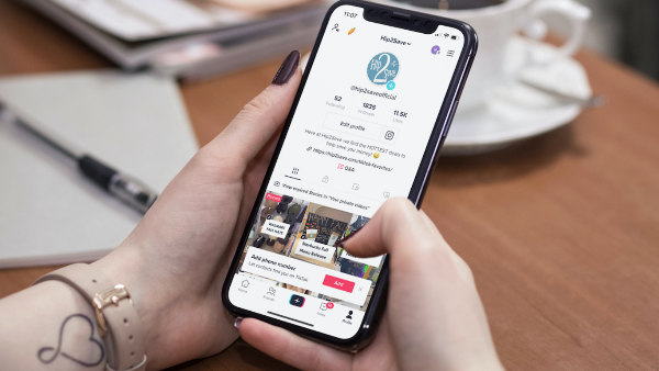 womens hands holding a phone with the TikTok app open