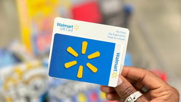 hand holding a blue and yellow walmart gift card