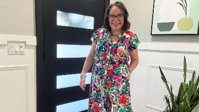 woman posing near a door wearing a floral jumper