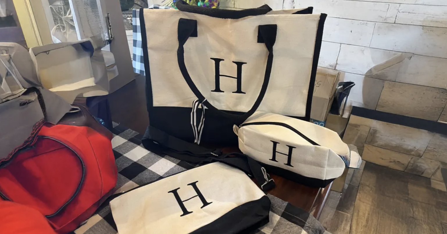 Canvas tote bags with the initial H on top of desk