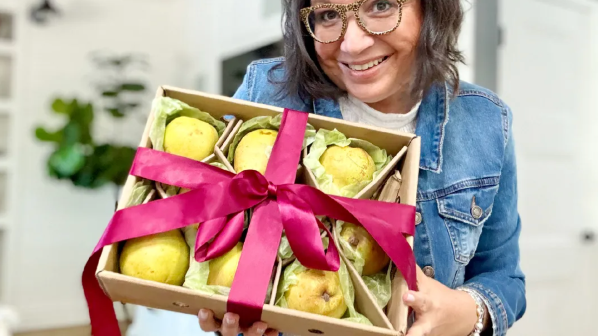 Woman holding wrap box of Harry and David, gourmet pears