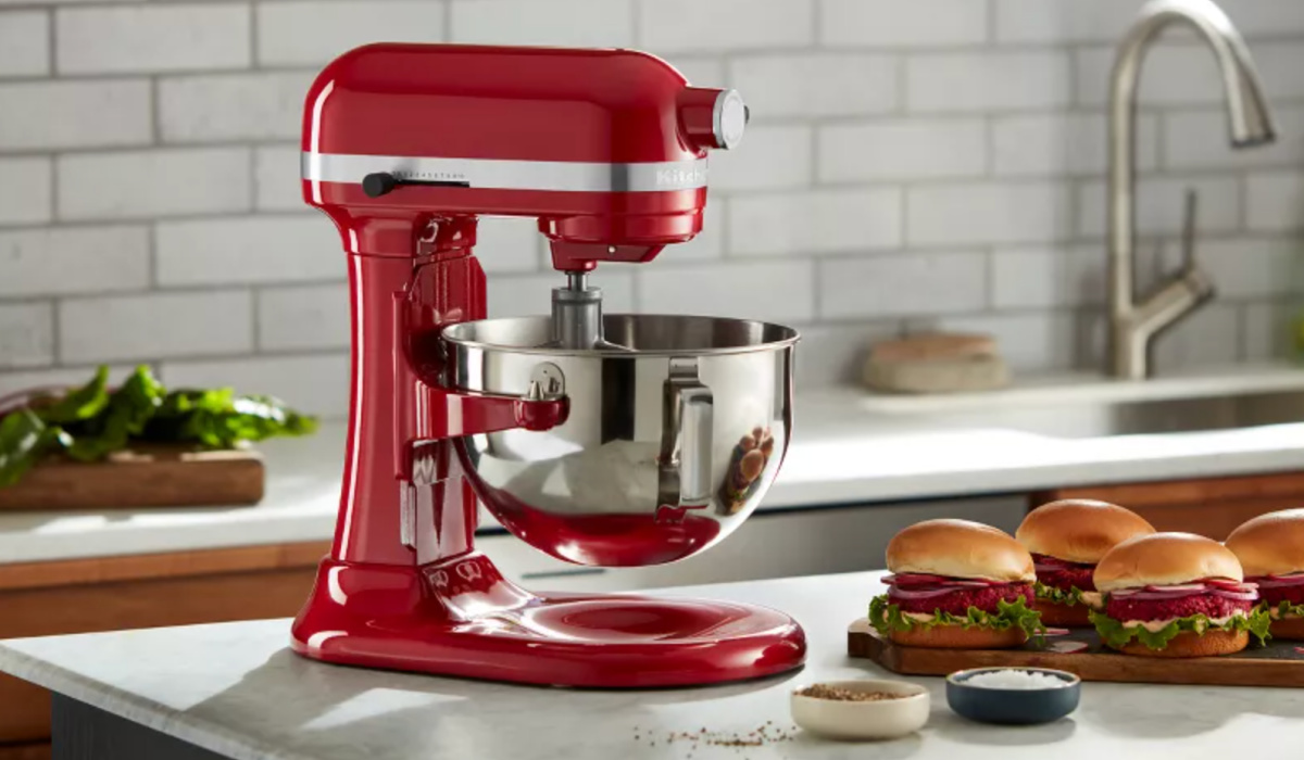 Red KitchenAid mixer on countertop next to hamburgers