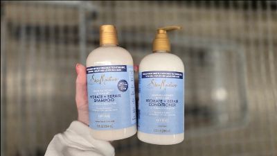 SheaMoisture hair care bottles in hand