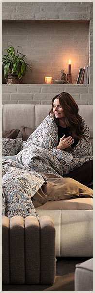 Barna hajú nő ágyneműbe takarózva