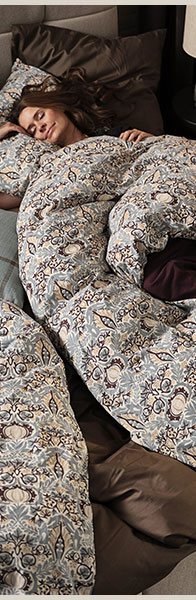 Barna hajú nő az ágyban fekve pihen