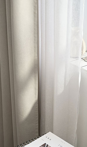 Közeli egy bézs és fehér függönyről