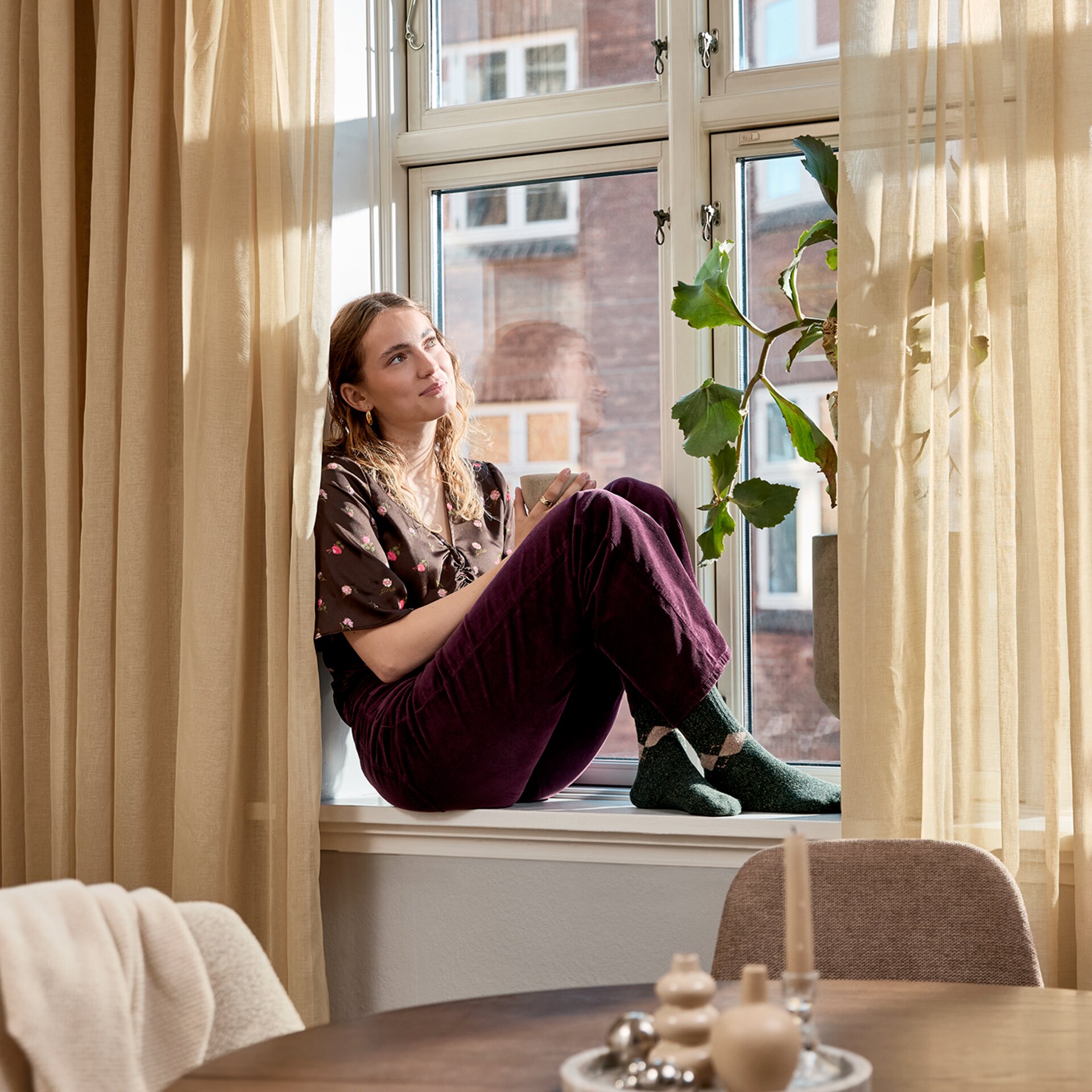 Egy nő ül az ablak mellett