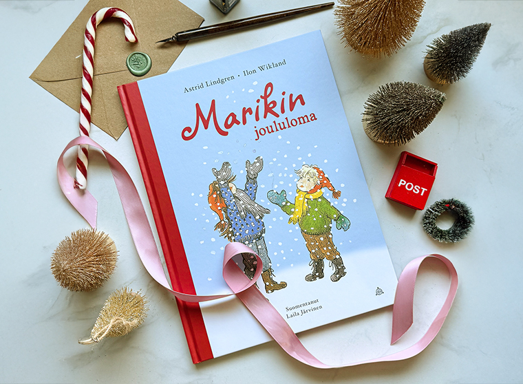 Kuvassa on kirja Marikin joululoma ja jouluista rekvisiittaa.