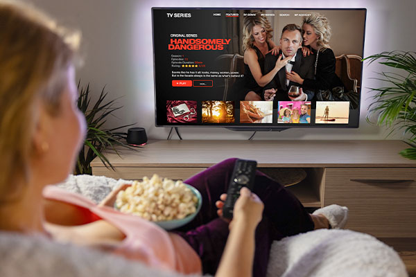 Vrouw op de bank met afstandbediening in de hand voor de tv