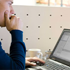 Man moeilijk kijkend achter een laptop