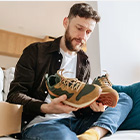 Man die schoenen uit een doos haalt