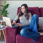 Mevrouw op de bank met een laptop