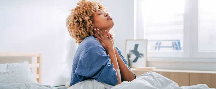 Vrouw zit op bed bij daglicht