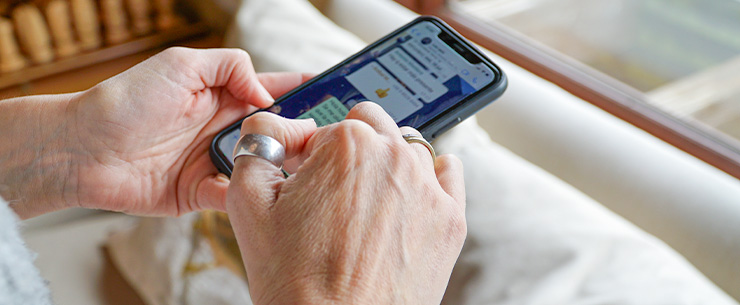 Handen houden een smartphone vast met een chatgesprek op het scherm